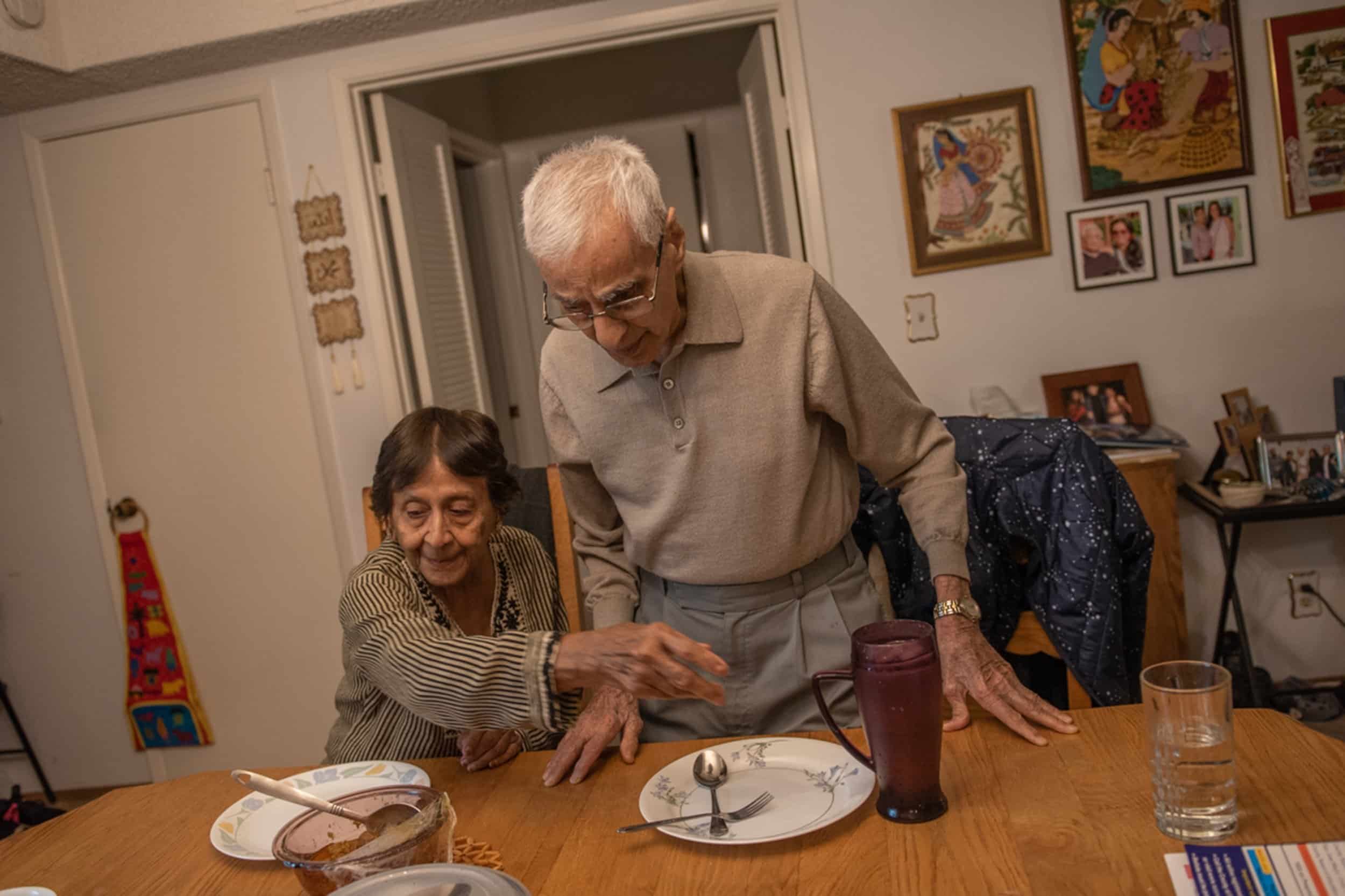 Tahera Khalil helps her husband Sabbar Kahlil at dinnertime. Photo by Sree Sripathy for India Currents/CatchLight Local