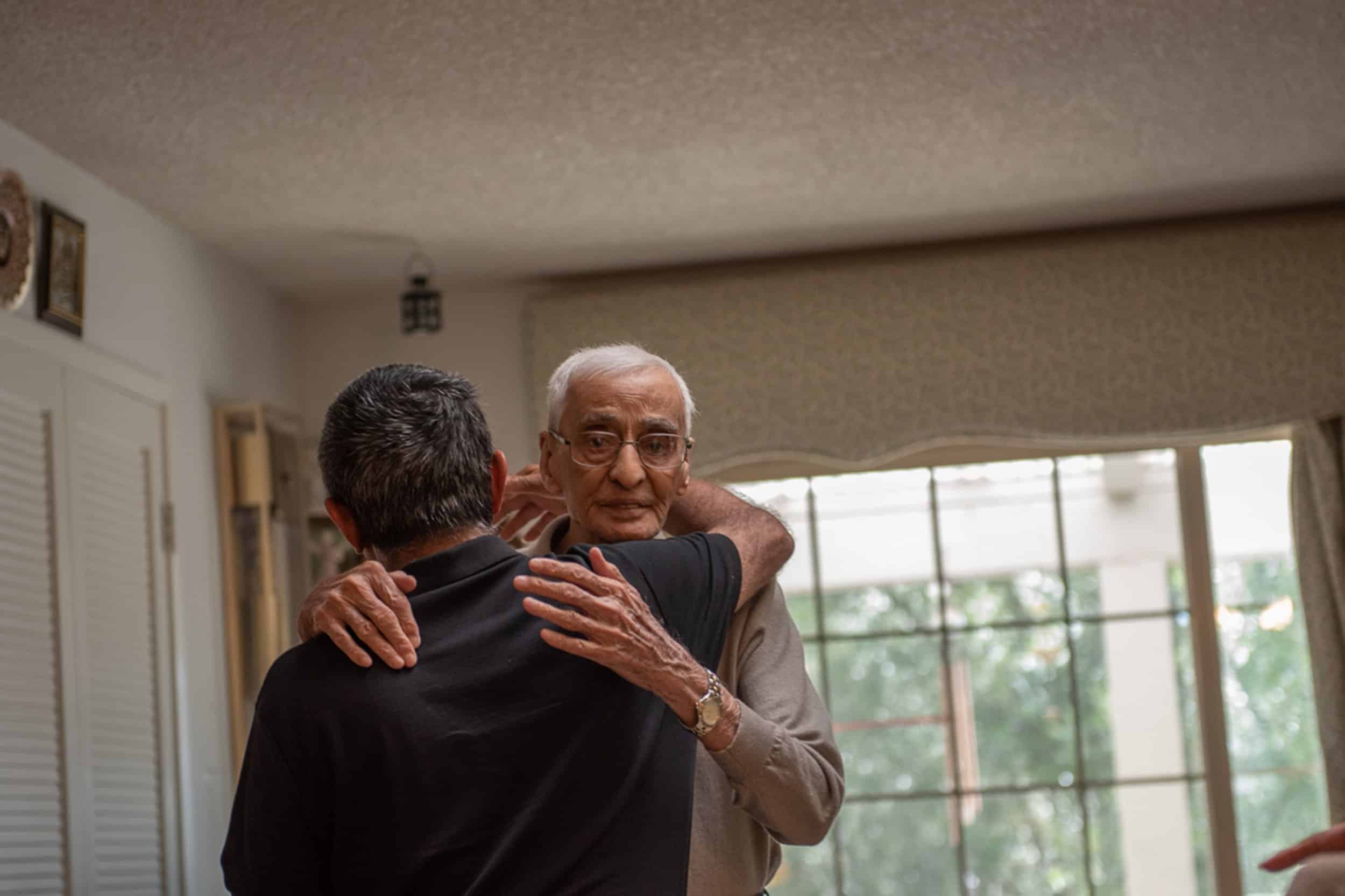 Sabbar hugs his son, Nazir Khalil, who is returning home to New Mexico. Nazir visits his parents frequently. Photo by Sree Sripathy for India Currents/CatchLight Local